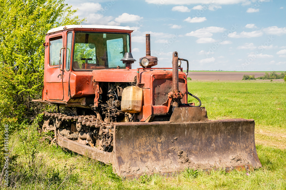 Red old rusty tractor in a field Red old rusty tractor in a field