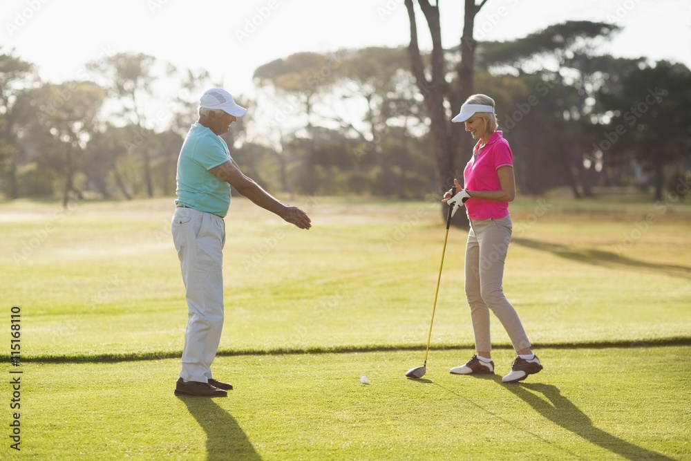 Obraz premium Side view of mature male golf player teaching woman