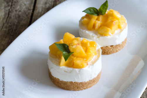 Cheesecake with peaches on wooden background