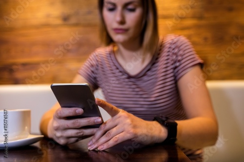 Woman using mobile phone at table