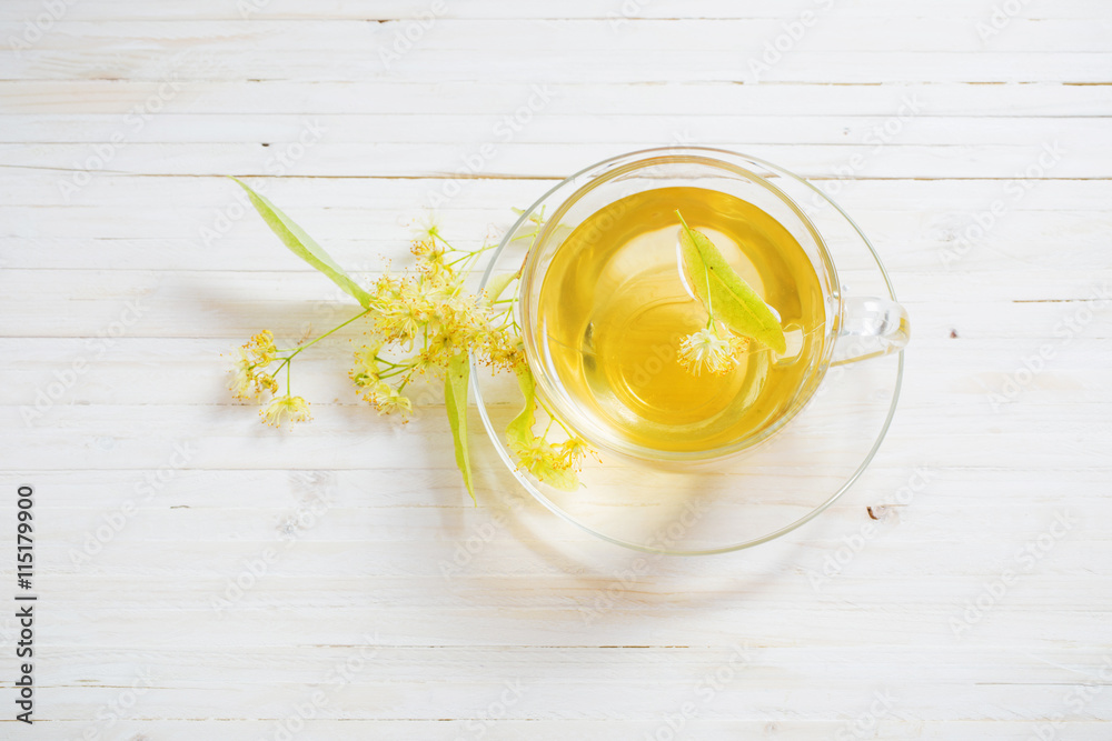 cup of tea and linden flowers on a wooden background cup of tea and linden flowers on a wooden background