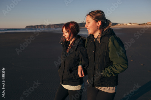 Two Girl Friends on the Beach Laughing and Walking © maxwellmonty
