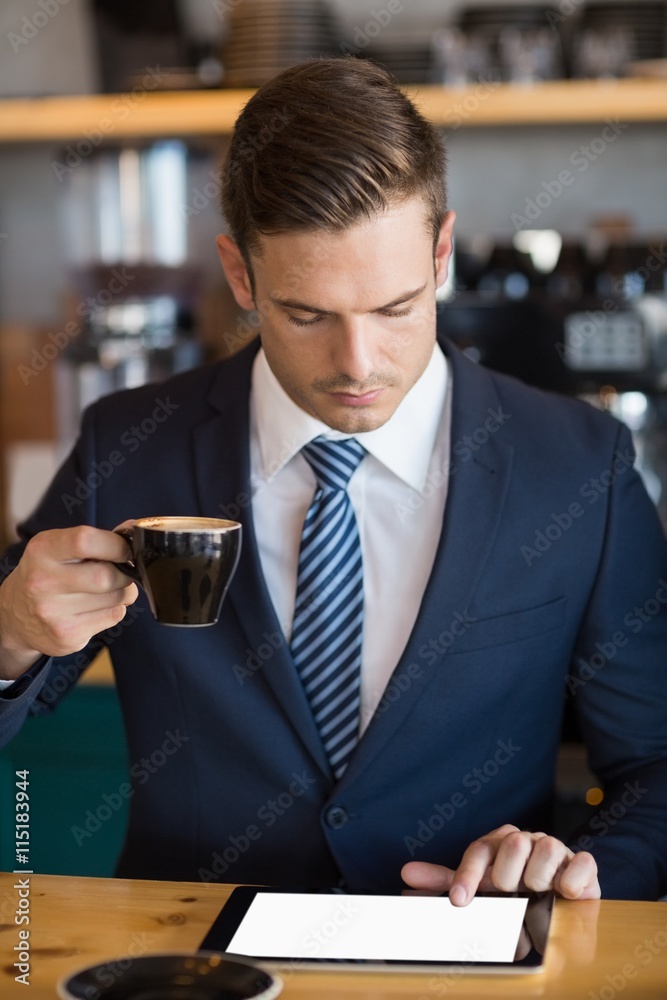 Close-up of businessman using digital tablet in café