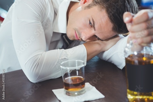 Drunken man lying on a bar counter