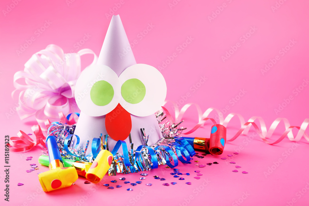 Funny party hat with blowers on pink background