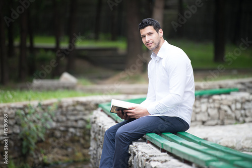 Young Muslim Guy Reading The Koran