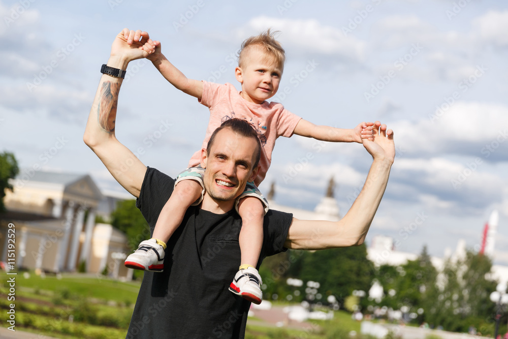 Son on the shoulders of his father in the park Son on the shoulders of his father in the park