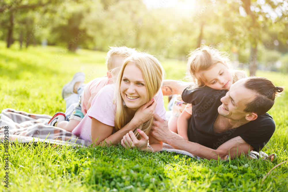 Fototapeta premium Rodzina bawić się w parku na trawie