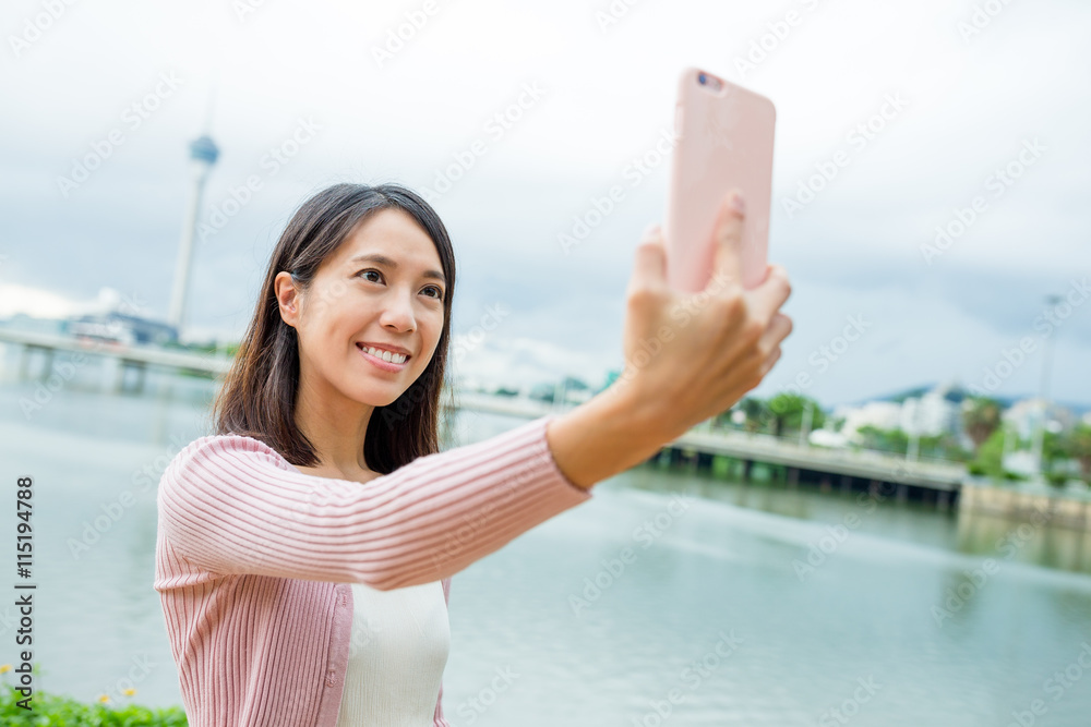 Woman taking selfie by mobile phone in Macau Woman taking selfie by mobile phone in Macau