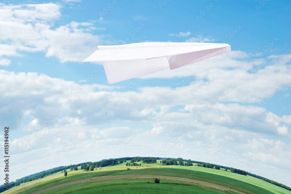 Fototapeta premium Toy paper plane flying high in the sky over the Earth