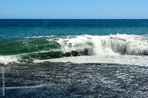 Waves in the sea. Black sand volcanic beach