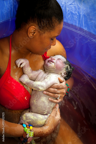 Mother Cradels Newborn In Birthing Tub