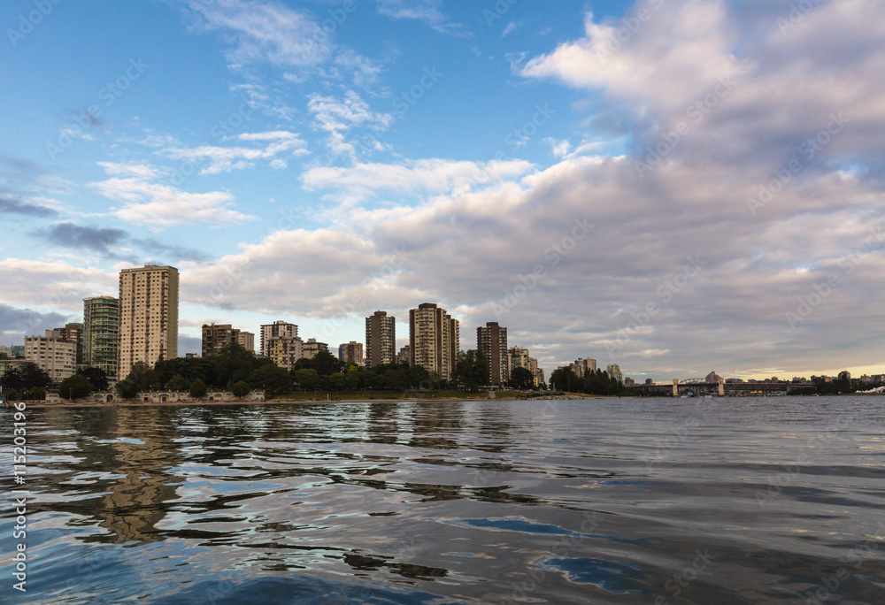 View of English Bay Beach and Residential Buildings in Downtown Vancouver from the water during sunset.