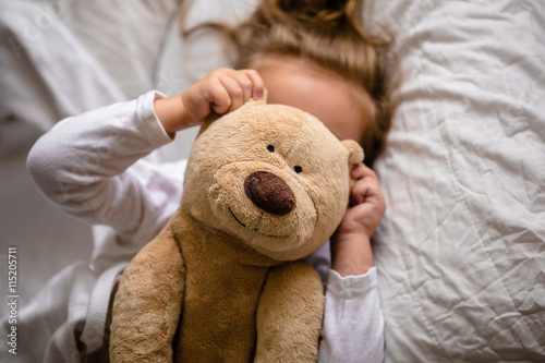 little girl in bed with soft toy the emotions of a child