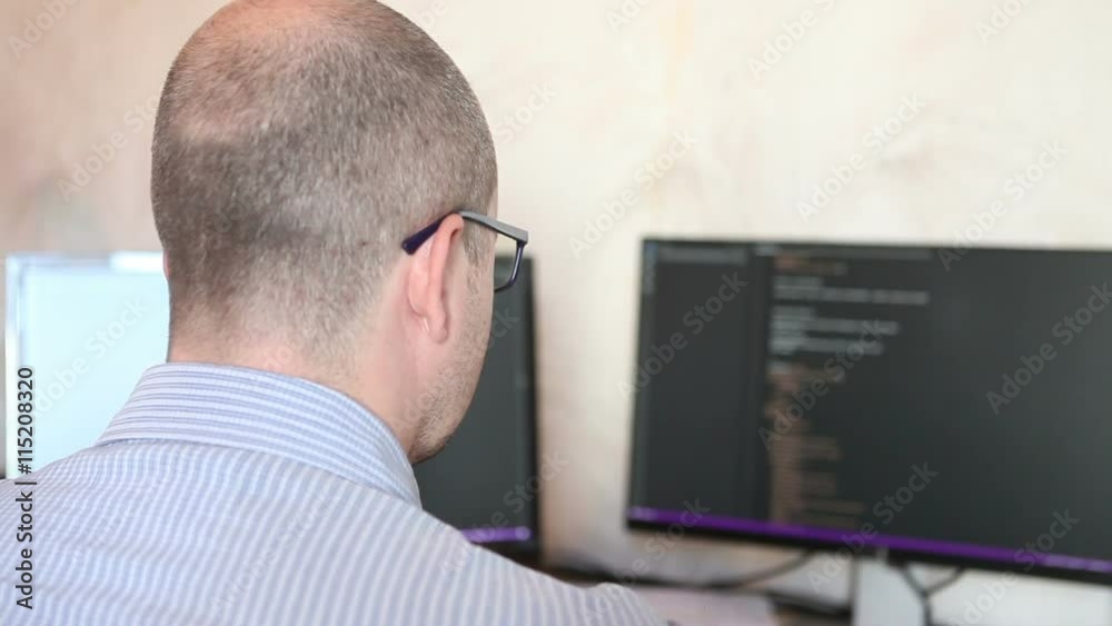 man with glasses working at the computer and t tired eyes man with glasses working at the computer and t tired eyes