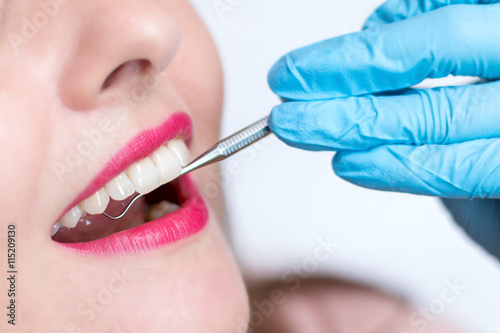 Fototapeta Naklejka Na Ścianę i Meble -  Close-up of young woman at dental visit. Stomatologist examining a young lady's teeth
