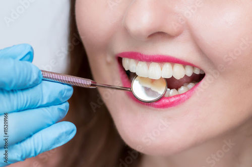 Close-up of young woman at dental visit. Stomatologist examining a young lady's teeth