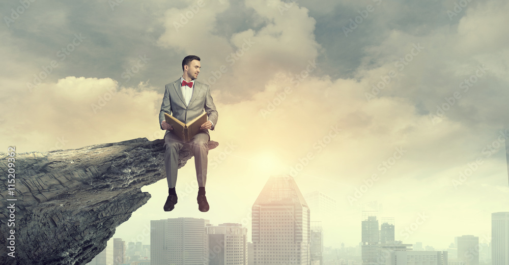 Businessman reading old book . Mixed media Businessman reading old book . Mixed media