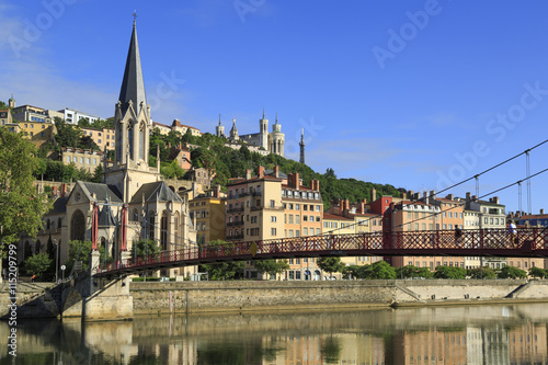 Pedestrians on the Saint Georges footbridge and the Saint Georges church in Lyon, France.