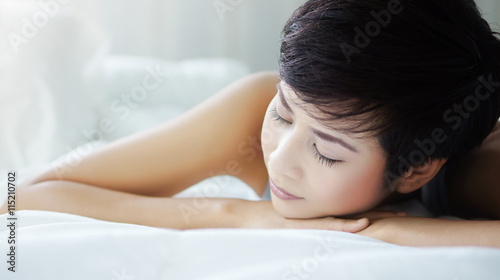 Woman sleeping happily in bed in the morning