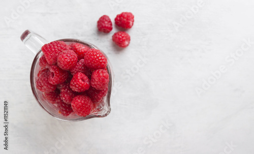 Red raspberry in cups on a white background