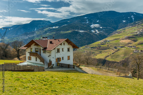 House next to the pasture on mountains background,
