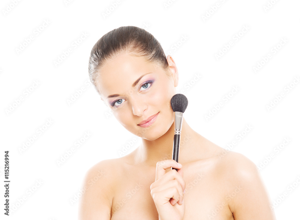 Portrait of a young woman holding a makeup brush