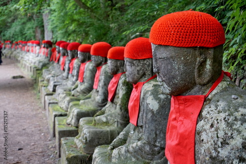 Row of many small stony sculptures of buddhas (Kanmangafuchi) in Nikko, Japan