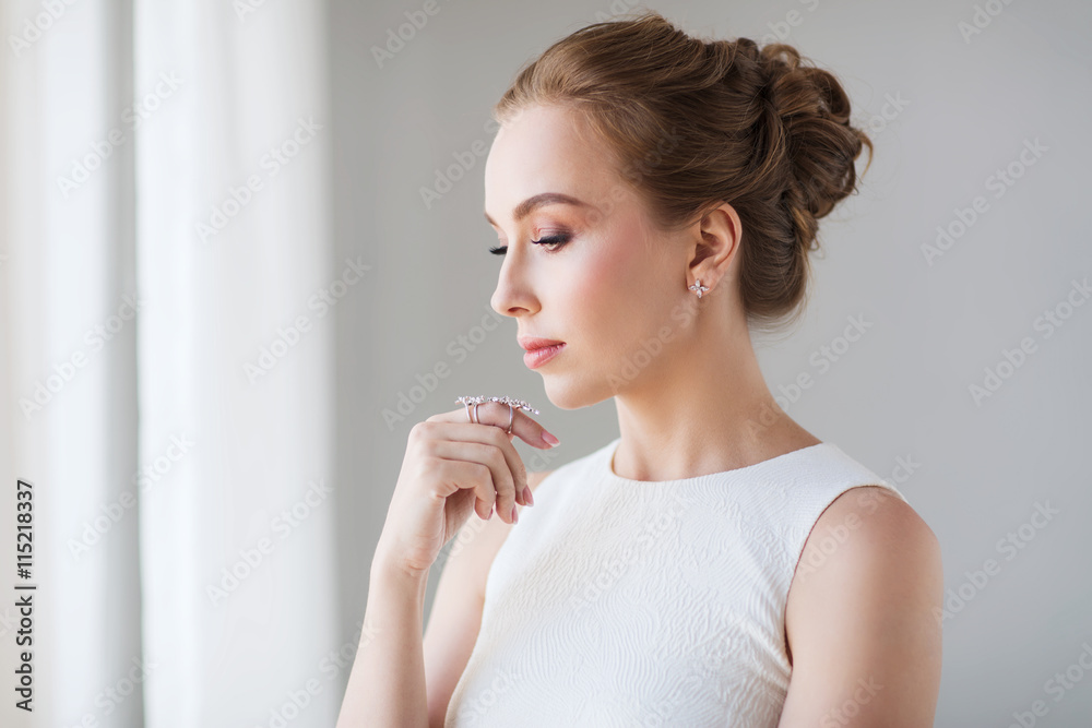 smiling woman in white dress with diamond jewelry
