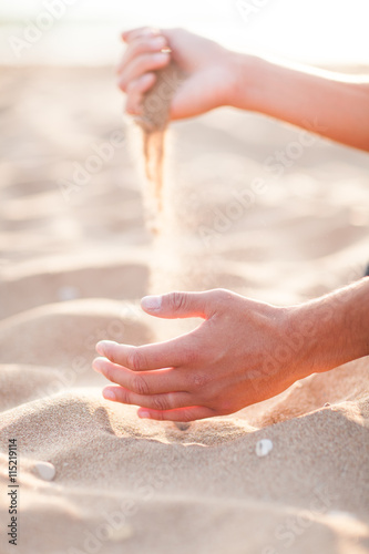 Man adding coarse sand to a heap with his hands. Very shallow de