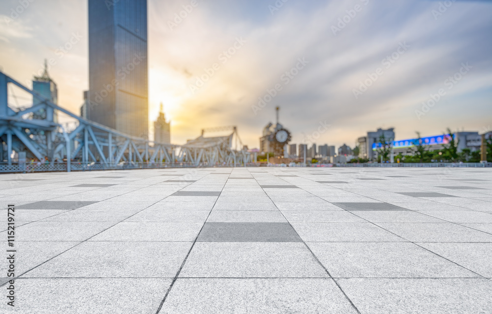 empty pavement and city skyline during sunset