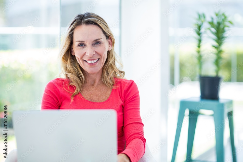 Woman smiling while using laptop Woman smiling while using laptop