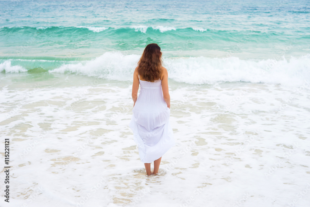 Beautiful brunette going to the wavy ocean