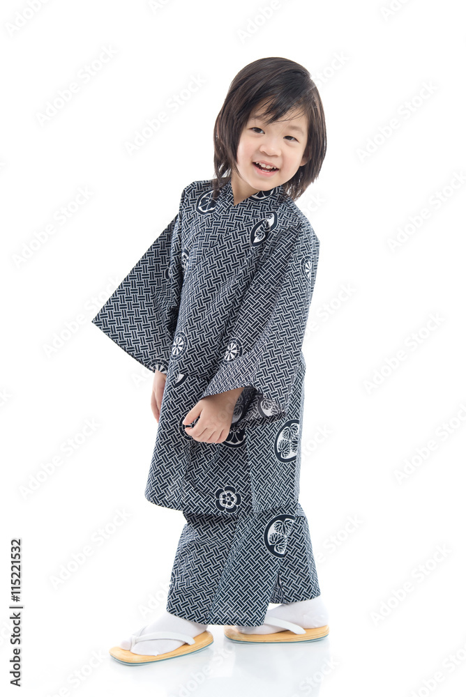 Fotografie Happy asian boy in kimono sitting on white background