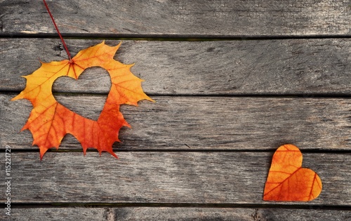 Autumn leaves. Autumn leaves hearts on wood background.