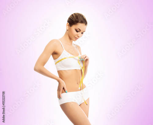 Young and fit woman measuring her chest with a tape © Acronym