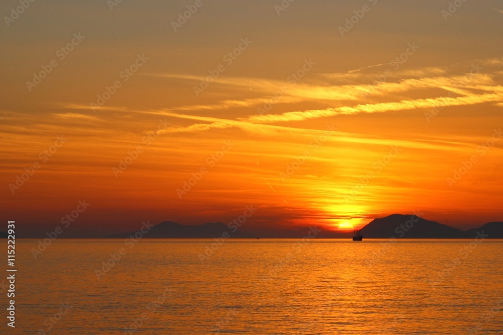 Sunset on Adriatic sea with touristic ship on horizon