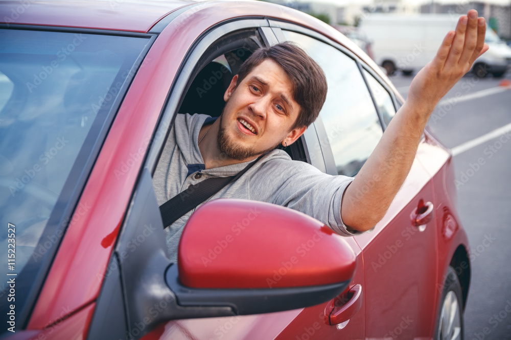 The young man driving the car angry, stuck in a traffic jam The young man driving the car angry, stuck in a traffic jam