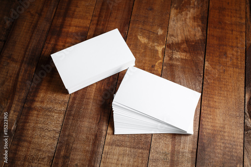 Photo of blank business cards on vintage wooden table background. Mock up for design portfolios. Responsive design template. Top view.