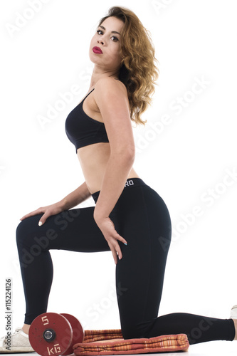 Piękna kobieta brunetka ćwiczy w siłowni