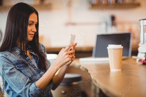 Woman using mobile phone at office cafeteria