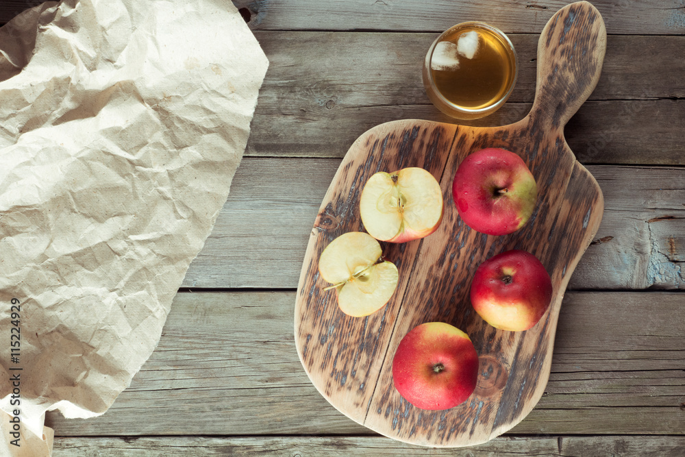 apples on a cutting board and glass of juice apples on a cutting board and glass of juice