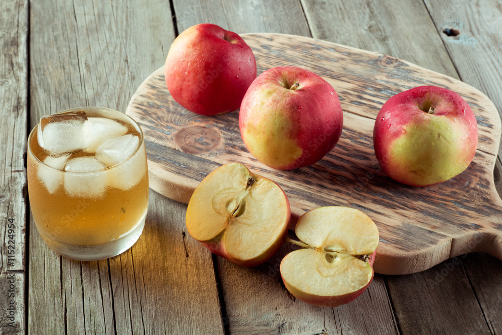 glass of juice and apples on a cutting board