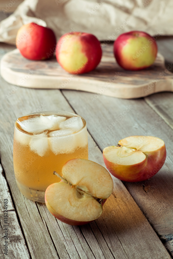 glass of juice and apples on a cutting board