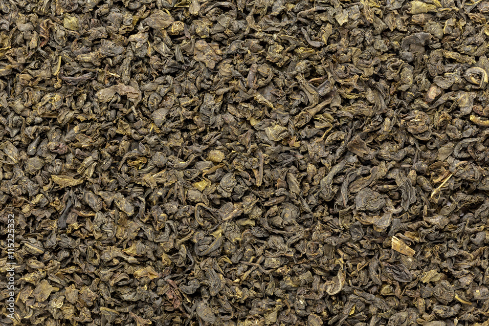Organic Green Tea (Camellia sinensis) dried whole leaves. Macro close up background texture. Top view. Organic Green Tea (Camellia sinensis) dried whole leaves. Macro close up background texture. Top view.