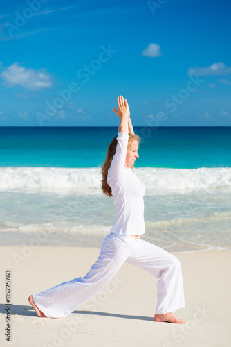 Woman practices yoga on the tropical beach