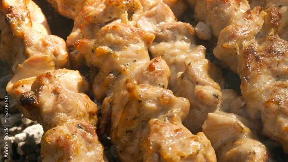 Slices of chicken meat on skewers,with burning coal and barbecue Slices of chicken meat on skewers,with burning coal and barbecue