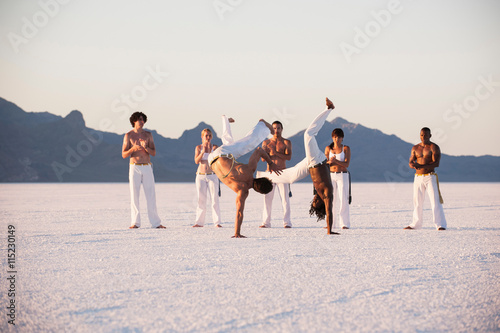 People practicing capoeira in desert