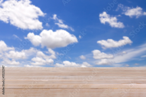 brown wood table top on bokeh abstract blue sky background - can