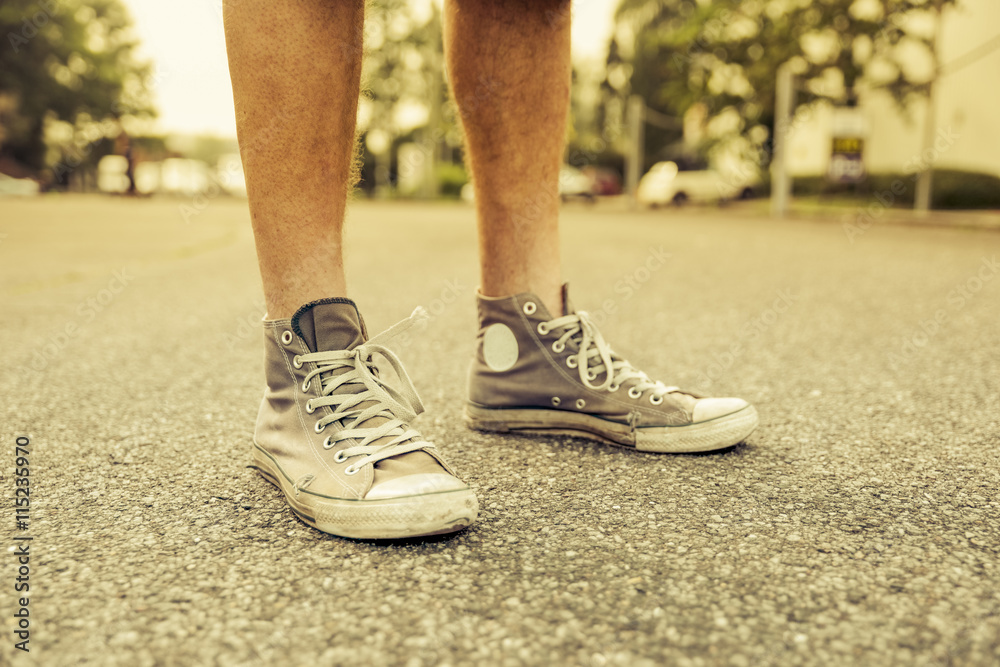 Man's feet with old sneakers, close-up